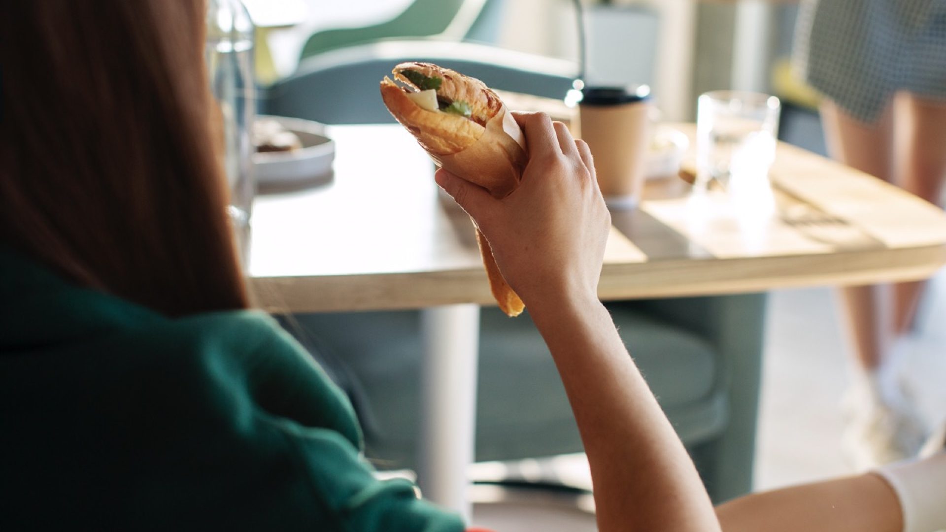 side-view-woman-with-paper-wrapped-sandwich - dimensioni grandi